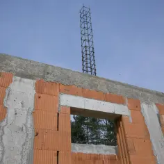 Budowa domu w toku: wieniec ściany szczytowej z pustaków ceramicznych, betonowy nadproże okna i zbrojenie słupa.