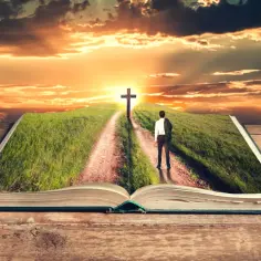 Otwarta księga ukazuje ścieżkę prowadzącą do krzyża na wzgórzu. To jak żywe biblia cytaty, inspirujące do podążania za wiarą.
