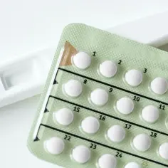 Test ciążowy i opakowanie tabletek antykoncepcyjnych. Decyzja o metodach antykoncepcji i planowaniu rodziny.