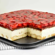 Sernik gotowany z truskawkami w galaretce, przełożony biszkoptem i kremem. Absolutny hicior, który zachwyci każdego!