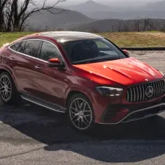 Czerwony Mercedes-AMG GLE coupe z panoramicznym dachem, zaparkowany na tle górskiego krajobrazu.