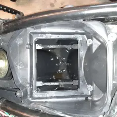 Wnętrze obudowy filtra powietrza motocykla, widoczna jest odma z olejem.