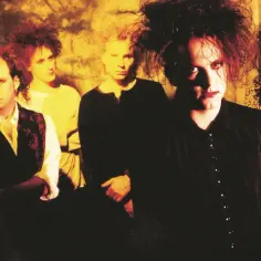 Pięciu członków zespołu The Cure z charakterystycznymi fryzurami i makijażem, gotowych do wykonania swojej mrocznej muzyki.