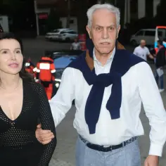 Para, ile lat ma Justyna Kulka? Kobieta w czarnej sukience i mężczyzna w białej koszuli, z granatowym swetrem na ramionach, idą razem.