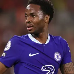 Raheem Sterling w niebieskiej koszulce Chelsea, patrzący w bok.