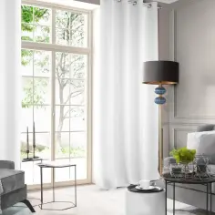 Elegancka sztukateria w salonie aranżacje: szare meble, białe zasłony i stylowa lampa tworzą przytulną atmosferę.