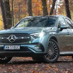 Szary Mercedes-Benz GLC 300 na tle jesiennego lasu.
