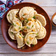 Talerz pysznych, domowych pierogów z cebulką i szczypiorkiem. Zastanawiasz się, ile wyjdzie pierogów z pół kilograma mąki? Tyle pyszności!
