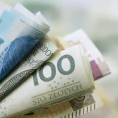 Zwijane polskie banknoty, w tym 100 złotych, symbolizujące świadczenie rehabilitacyjne.
