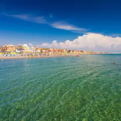 Słoneczny dzień nad morzem, idealne miejsce gdzie z Rzymu nad morze. Plaża pełna leżaków i parasoli, woda krystalicznie czysta.