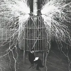 Nikola Tesla w swojej klatce, otoczony wyładowaniami elektrycznymi, badał, kto wynalazł prąd.