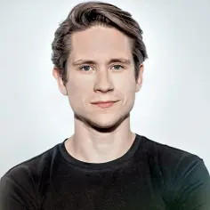 Michał Meyer, znany z filmów, seriali i programów, prezentuje się w czarnej koszulce na jasnym tle.