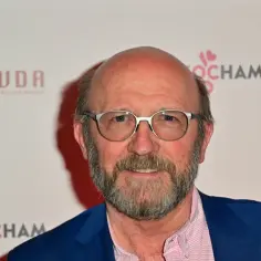 Artur Barciś, znany z wielu kultowych filmów, w okularach i niebieskiej marynarce.