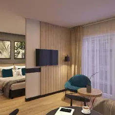 Przytulny pokój w hotelu Tulip Residences Warsaw Targowa. Łóżko, fotel, sofa i stolik kawowy tworzą komfortową przestrzeń.