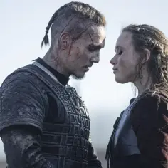 Ubrany w zbroję Uhtred i piękna kobieta, zmagają się z trudami w "Upadek Królestwa". Obsada serialu w dramatycznym ujęciu.
