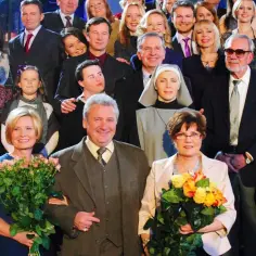 Wszyscy aktorzy grający w klanie, w tym dzieci, dorośli i starsi, pozują do zdjęcia na schodach.