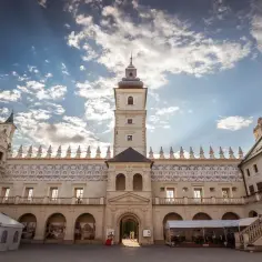 Wspaniałe zwiedzanie zamku Krasiczyn. Dziedziniec z wieżą i kopułą pod błękitnym niebem.