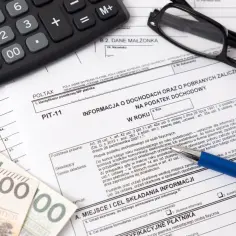 Kalkulator, okulary i pieniądze leżą na druku PIT-11. Zastanawiasz się, do kiedy PIT-11? Termin składania mija z końcem lutego.