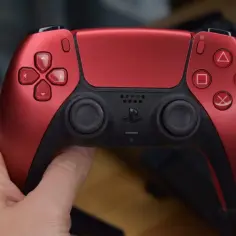 Czerwony kontroler DualSense. Zastanawiasz się, czy gry z PS4 działają na PS5? Tak, większość z nich jest kompatybilna!