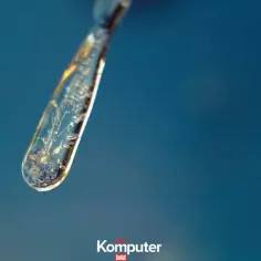 Kropla księcia Ruperta zamarznięta w krysztale, z widocznymi wewnątrz pęcherzykami powietrza.