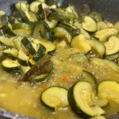 Pokrojona cukinia dusi się na patelni w aromatycznym sosie. To pyszna cukinia z grilla, która zachwyca smakiem.