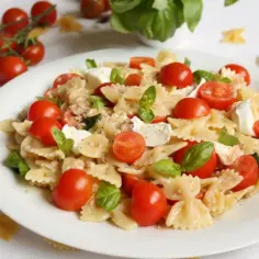 Sałatka z makaronem farfalle, pomidorkami koktajlowymi, mozzarellą i bazylią.
