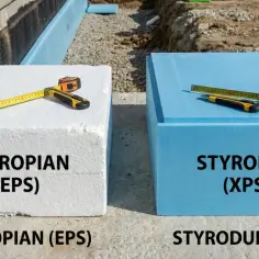 Biały styropian (EPS) i niebieski styrodur (XPS) leżą obok siebie. Narzędzia budowlane leżą na płytach.