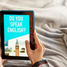Osoba przegląda na tablecie aplikację loora z pytaniem "DO YOU SPEAK ENGLISH?" i zdjęciem Big Bena.