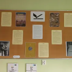 Tablica z plakatami o literaturze, w tym "Diabły z Nasy Modenese" Pablo Trincia, nagroda Kapuścińskiego, "Las Duchów" i "Biuro Przezuć" Sam Knight.