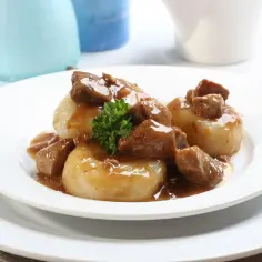 Pyszne kluski śląskie polane gęstym, aromatycznym sosem z kawałkami mięsa. Idealny sos do klusek śląskich.