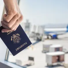 Dłoń trzyma paszport USA. Czy do Emiratów Arabskich potrzebny jest paszport? Tak, jest niezbędny do podróży.