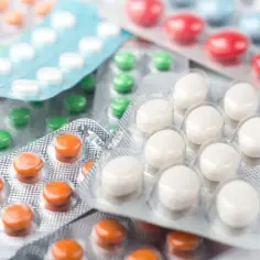 Blistry z tabletkami: zielone, pomarańczowe, białe, czerwone i niebieskie. Może wśród nich jest Duspatalin retard, który przyniesie ulgę.