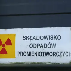 Tabliczka z symbolem promieniowania ostrzega przed składowiskiem odpadów promieniotwórczych.