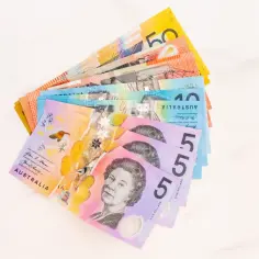 Kolorowe banknoty dolarów australijskich ułożone wachlarzowo. Widać nominały 5, 10, 50. To pokazuje ceny w Australii.