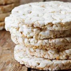 Stos wafli ryżowych na drewnianym blacie. Idealne na lekki posiłek, gdy liczymy wafle ryżowe kcal.