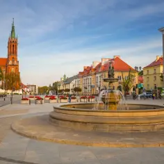 Fontanna na rynku w Białymstoku, stare miasto. W tle kościół i kamienice.