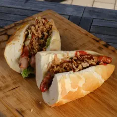 Dwa pyszne hot dogi z grilla, podane na desce, z chrupiącą cebulką i sosami.
