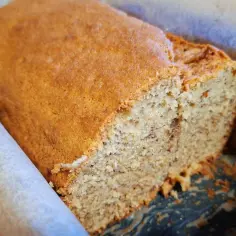 Pyszny chlebek bananowy Ani gotuje się w piekarniku. Widać jego wilgotne wnętrze z kawałkami banana.