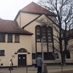 Synagoga w Gdańsku, z charakterystycznymi oknami i menora przed budynkiem.