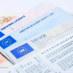 Brytyjskie prawo jazdy, karta kwalifikacji kierowcy, banknot 10 funtów i paragon. Zastanawiasz się, ile się czeka na prawo jazdy?