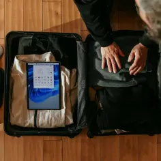 Pakowanie walizki na lot. Zastanawiasz się, ile kosztuje walizka w lot? W środku ubrania, buty i tablet.