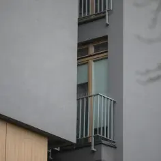 Szare bloki z drewnianymi elementami, wąskie okna i balkony z kolcami. Typowa patodeweloperka, gdzie estetyka ustępuje miejsca funkcjonalności.