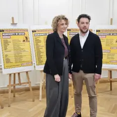 Para na tle plakatów z rankingiem remontów w Łodzi.