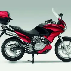 Czerwona Honda Varadero 125 z kufrem, gotowa na odblokowanie pełnego potencjału.