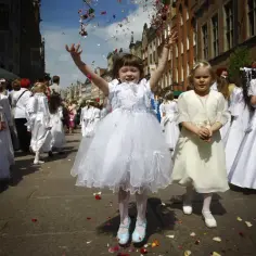Dzieci w białych strojach sypią kwiaty, celebrując uroczystość. To pytanie "dlaczego Boże Ciało jest w czwartek" jest często zadawane.