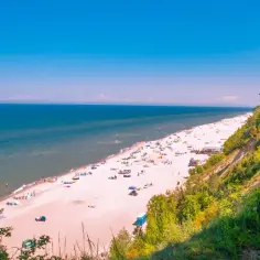 Piękna plaża z turkusowym morzem i zielonym klifem. Idealne miejsce, gdzie na wakacje nad morze.