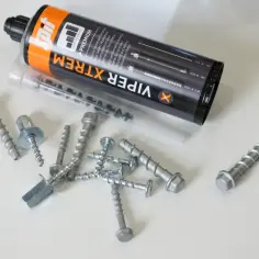 Zestaw śrub do betonu Viper Xtreme, w tym kilka sztuk z łbem sześciokątnym i podkładką, obok tuby z zaprawą chemiczną.