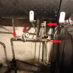 Instalacja hydrauliczna bojlera z zaznaczonym zaworem bezpieczeństwa i manometrem.