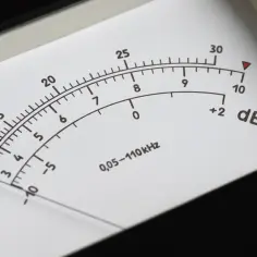 Wskaźnik mierzy poziom dźwięku w decybelach (dB). Igła wskazuje wartość około 10 dB.