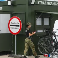 Strażnicy graniczni prowadzą kontrole na granicy niemieckiej. Obok zielonego punktu kontrolnego stoją rowery na bagażniku samochodu.